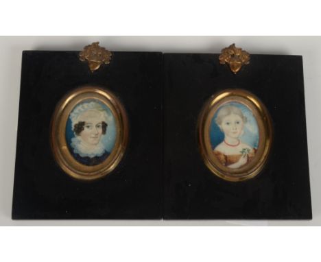 A George III English Provincial School portrait miniature of a lady in blue with lace cap and collars.