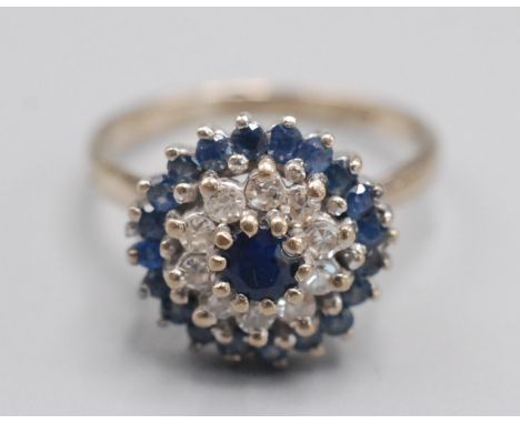 An 18ct. white gold sapphire and diamond target cluster ring.