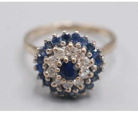 An 18ct. white gold sapphire and diamond target cluster ring.