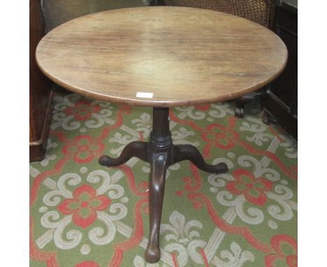 A George III mahogany tripod table, the circular top on a ring turned stem, on cabriole supports and pad feet, height 85cm.  