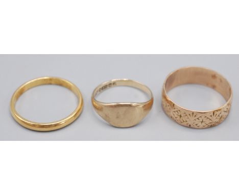 An engraved 15ct gold band, 4.3g, a 22ct gold band, 3.1g and a 9ct gold signet ring, 2.2g.