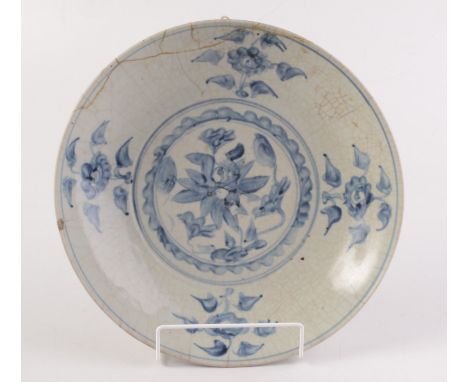 A Chinese South East Asian Export saucer dish decorated in under glaze blue on a crackled creamy glaze with a central medalli