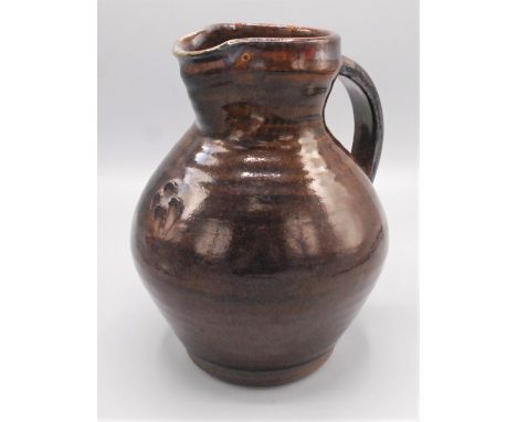 A Leach pottery jug with a treacle glazed ribbed body, impressed mark to base, height 20cm.