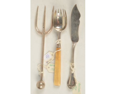 A silver bread fork and two other silver pieces. 
