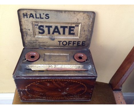 Hall's State toffee tin with lid opening to inkstand, 2 ceramic wells, and a pen all decorated in faux mahogany style some pa