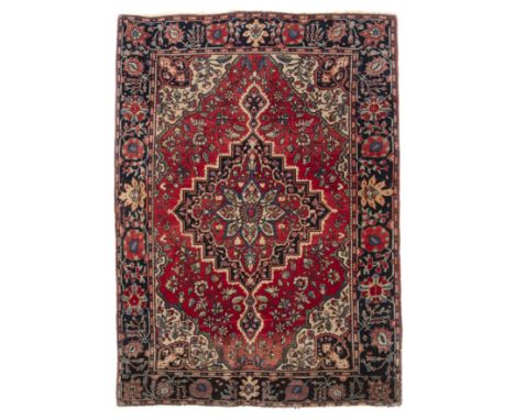 A early to mid 20th century Persian style rug with diamond shaped medallion on rose coloured ground having foliate decoration