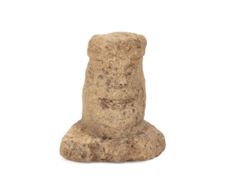 A Celtic limestone head or boundary marker, carved with a top knot, with weathered features on the face and a broad base 4th 