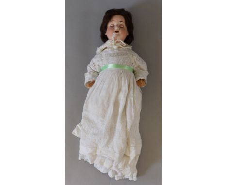 A vintage Schoenau & Hoffmeister doll, clothed, size 16, with some damage.