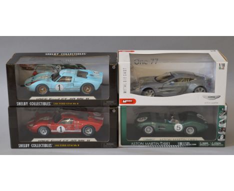 Four boxed 1:18 scale diecast model cars by Mondo Motors and Shelby Collectibles, including Aston Martin, Jaguar and Ford GT-