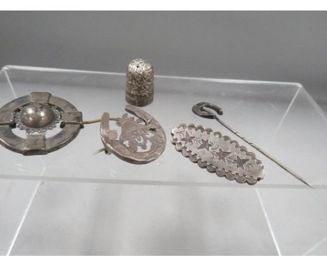 Antique silver and white metal jewellery, consisting of 3 brooches, a stick pin, together with a thimble 