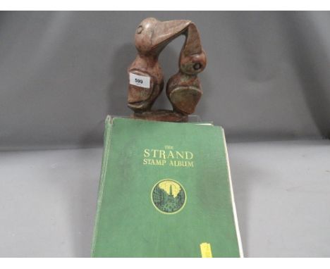 An African soap style carving of two birds together with a strand stamp album and contents 