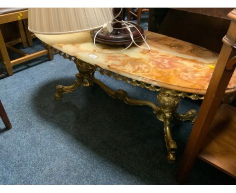 An oval onyx coffee table together with a mahogany standard lamp and shade 