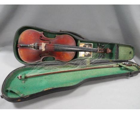 A cased vintage violin and bow with etched detailing 