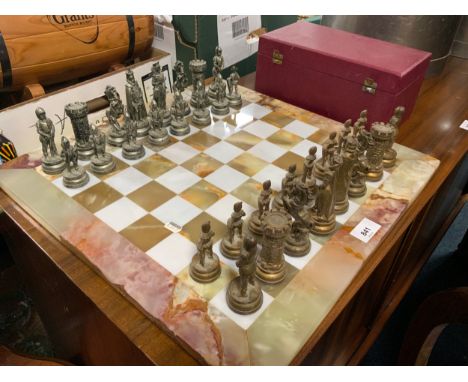 A modern onyx chessboard with gilt and silver colored pieces in an original Jaques chess box 