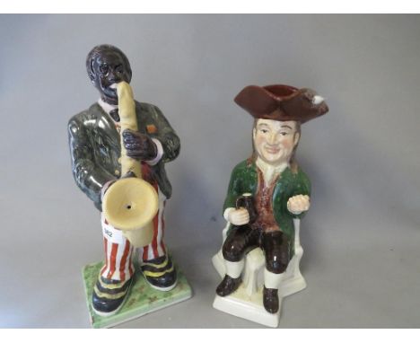 A modern reproduction figure of a saxophone player together with a toby jug 