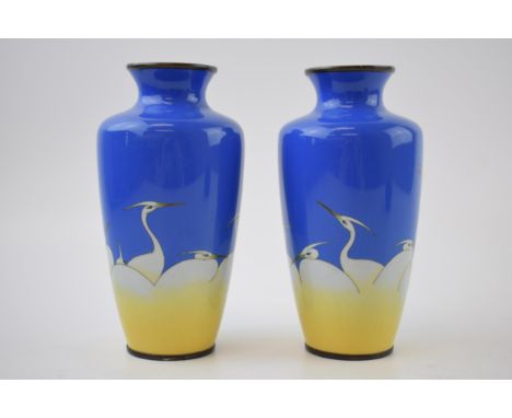 A pair of enamel cloisonne vases with stork decoration, 15.5cm tall (2).Generally good and clean condition. Minor chip to one