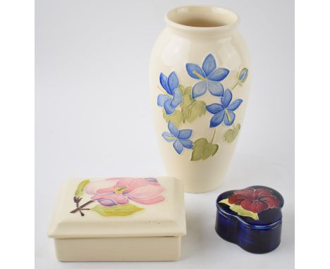 A trio of Moorcroft items to include a blue floral vase, 19cm tall, a Hibscus on magnolia trinket and a similar clover shaped