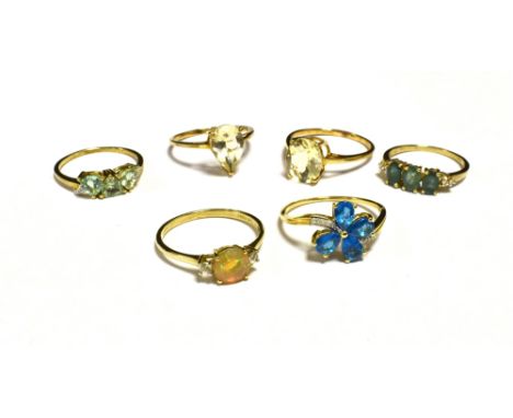 SIX DRESS AND COCKTAIL RINGS The rings set in coloured gem, stone and paste yellow metal shanks marked 10KT 417. Ring sizes Q