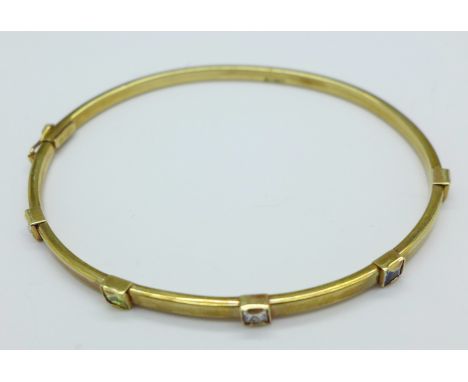 A 9ct gold bangle set with coloured stones, 4g