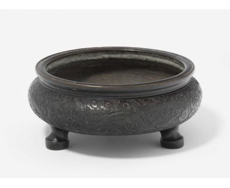RäuchergefässChina, 19./20.Jh. Bronze. Xuande-Marke in Siegelschrift am Boden. Gedrückte Rundform auf drei Beinen. Reliefiert