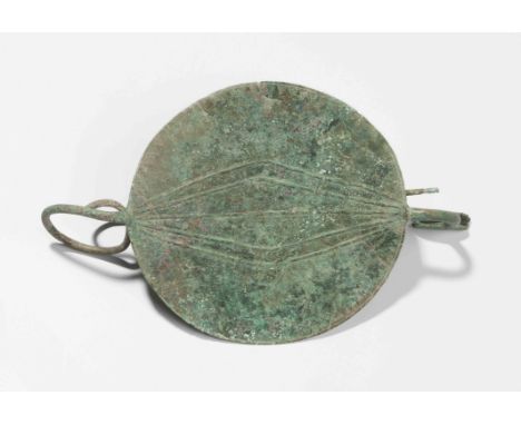 ScheibenfibelGriechisch-geometrisch, 7.Jh. v. Chr. Bronze. Scheibe mit gegossenem geometrischem Muster sowie an der Aussenkan
