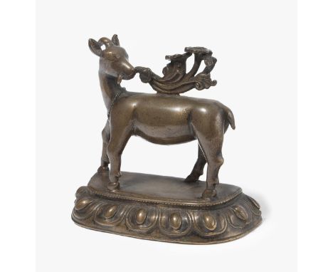 TierfigurNepal, wohl 18.Jh. Bronze. Einhörniger Ziegenbock steht auf einem Lotussockel und hält Blumen in seinem Maul. H 8,5 