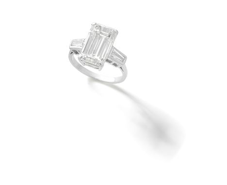 DIAMOND RINGThe step-cut diamond, weighing 6.51 carats, between tapered baguette-cut diamond shoulders, ring size LFor furthe