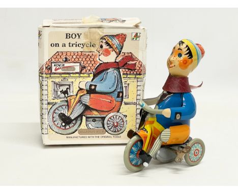 A vintage Kovap tinplate windup Boy on Tricycle in original box. 