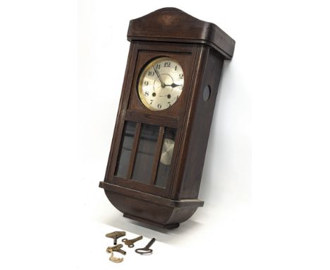 A 1930s oak cased wall clock, with keys and pendulum. 26x65cm 
