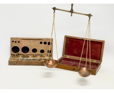A late 19th century brass and copper balance scales in case with A.H. Baird brass weights in case. 
