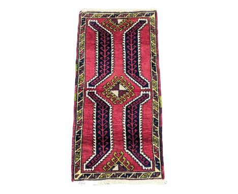 A vintage Middle Eastern hand knotted rug. 49x105cm 