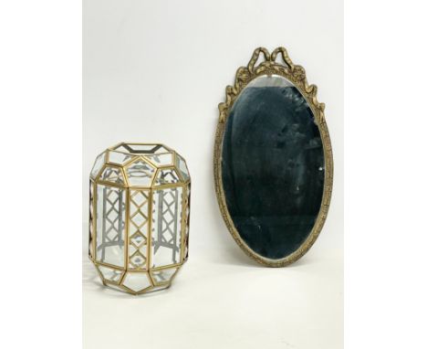 A brass and bevelled glass light shade and an ornate brass framed mirror. Shade measures 18x25cm 