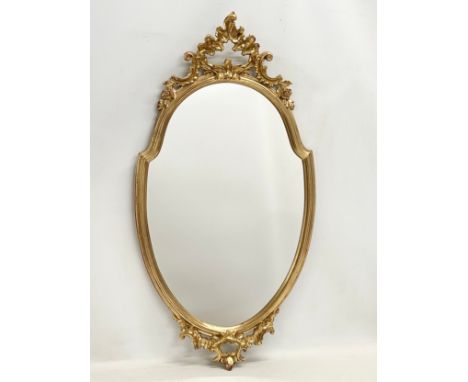 An ornate gilt framed mirror. 43x83cm 