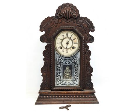 A late 19th century Ansonia oak Gingerbread clock with key and pendulum. 37x13x57.5cm 