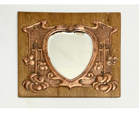 An Art Nouveau copper wall mirror on oak board. Circa 1900. 50.5x45.5cm 