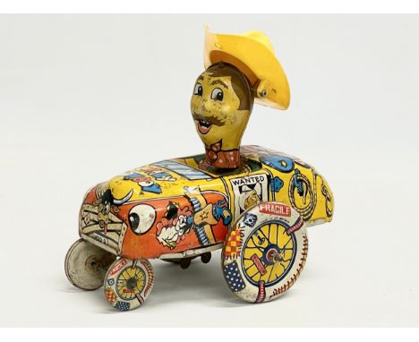 A vintage tin plate ‘Crazy Cowboy’ windup toy. Made in Great Britain. 16x16cm 