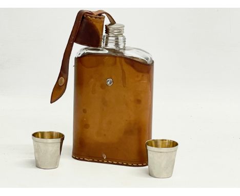 An early 20th century leather bound hip flask and 2 cups. 17cm 