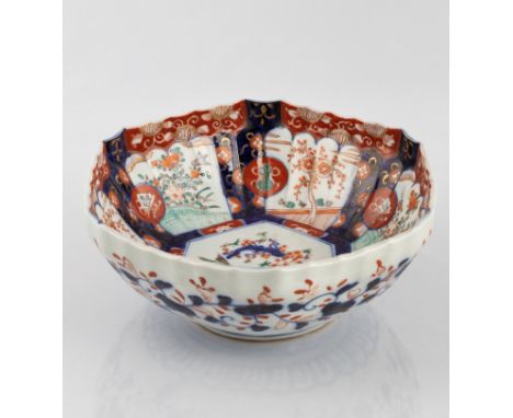The ribbed sides rising to a scalloped rim, each panel decorated with birds and flowers in a shaped cartouche, the central we