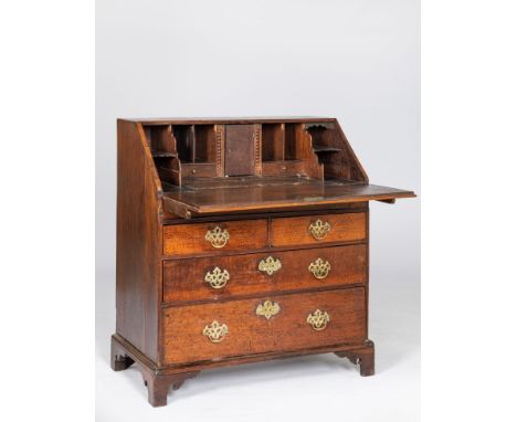 A GEORGE III OAK BUREAUThe rectangular top above a hinged fall-front enclosing a secret compartment, drawers and compartments