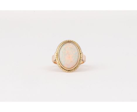 AN OPAL RINGBezel set to the centre with an oval opal, enclosed within a conforming rope-twist surround, in 14ct gold, size M