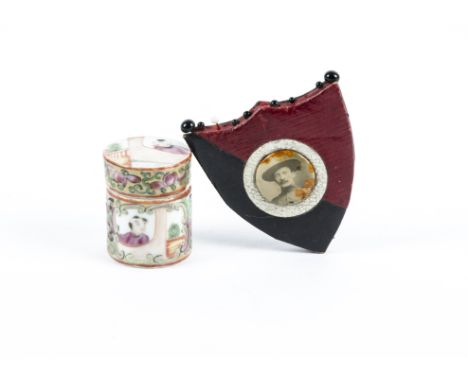 An early 20th Century leather pin cushion, shield shaped with a central button depicting a gentleman dressed in uniform (poss