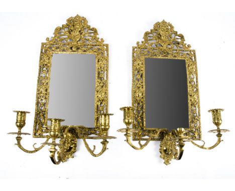 A good pair of brass girandole mirrors, the bevelled glass surrounded by intricate metal work with impressions of multiple ne