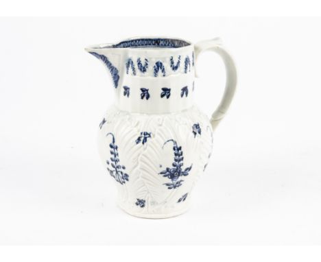 An 18th Century Caughley or Worcester cabbage leaf jug, with a moulded mask spout, painted in underglaze blue with floral spr