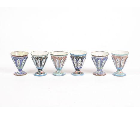 Six metal goblets with enamel decoration, likely of Eastern origin, each vessel with raised panels of floral decoration on a 