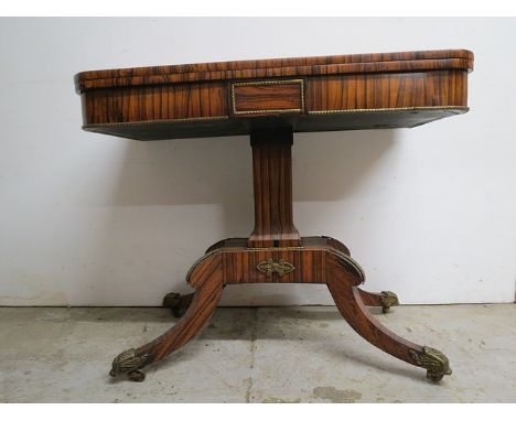 A Regency coromandel card table with gilt metal mounts having a rotating, foldover top enclosing a green baize surface, over 