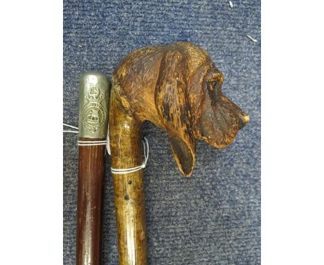 A late 19th/20th century walking stick, the handle carved as the head of a hound on a hazel shaft and a Duke of Wellington re