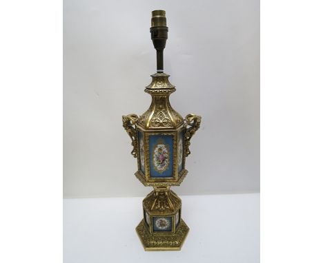 A late 19th century gilt metal octagonal table lamp with mask handles and Sevres style porcelain floral panels, on a pedestal