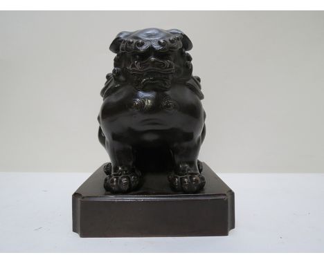 A late 19th/early 20th century Chinese cast and patinated bronze model of a guardian lion, on a plinth, 6 high