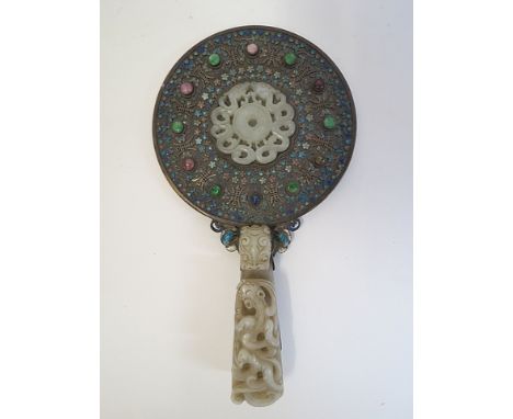 An 18th/19th century Chinese white metal and enameled hand mirror inset with a jade plaque carved as two dragons within a ban