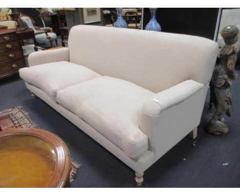 A modern Howard style two seat sofa, upholstered in a linen fabric, with loose cushion seats, on turned legs, 90 x 220cm  